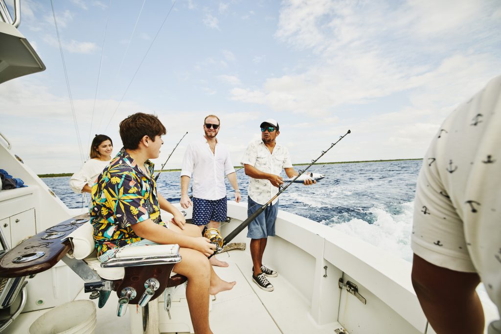 Wide shot of smiling family on sport fishing boat while on vacation